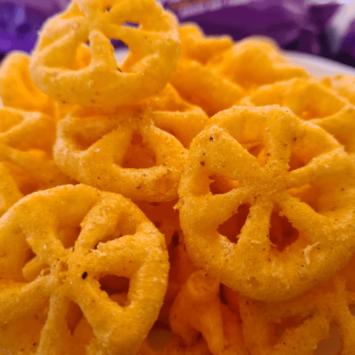 Golden Wonder Bikers Crisps: 20-Piece Box features crunchy, wheel-shaped snacks dusted with seasoning. A Northern Ireland favorite, their textured crisps sit in front of a blurred hint of purple Golden Wonder packaging.