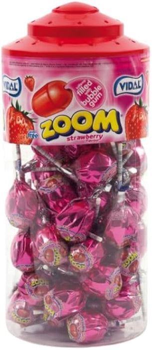 A clear plastic jar filled with wrapped lollipops, topped with a red lid and a pink label reading VIDAL ZOOM strawberry.