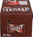 A 24-pack box of M&M's Chocolate candies, showing the brown cardboard packaging with a large M&M's logo and a sample candy wrapper displayed on the front.