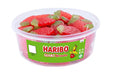 A clear plastic tub filled with large red and green strawberry-shaped gummy candies, with a green HARIBO GIANT Strawbs label on the front, isolated on a white background.