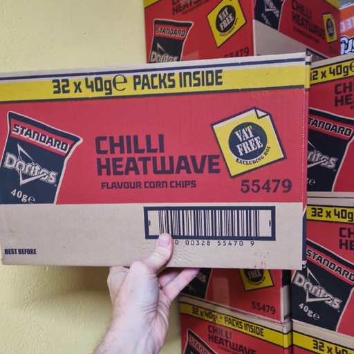 A person holds a box of Chilli Heatwave Doritos, displaying "32 x 40g packs inside," against a backdrop of stacked boxes.
