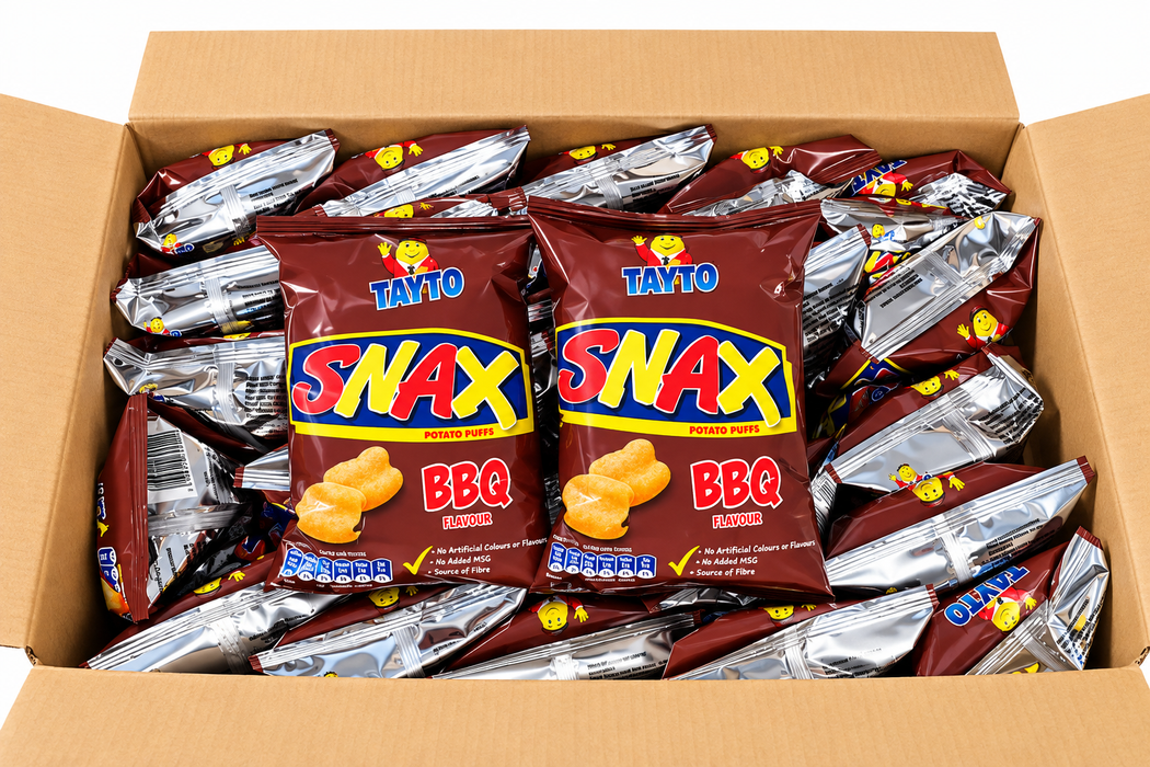 A cardboard box filled with multiple bags of Tayto Snax BBQ popcorn chips, showing the front two bags clearly against a white background.