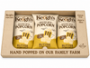 Three bags of Keoghs popcorn in a box with branding and product details.