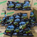 A stack of "Banshee Bones" snack bags in front of cardboard boxes, featuring vibrant packaging with eerie graphics.